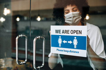 Restaurant female owner with protective face mask, reopens after lockdown quarantine. Business...