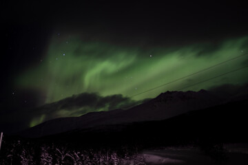 Northern Lights Above Mountain Silhouettes in Norway