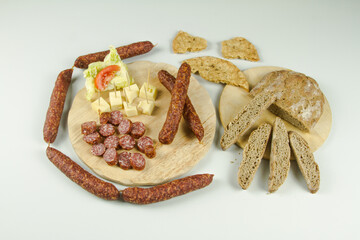 South Tyrolean snack dish such as Tyrolean smoked sausage on a wooden cutting board accompanied by kaminwurz and paarl type bread