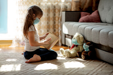 Little girl sitting with soft toys in a mask