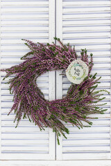 Blumenkranz aus Heidekraut hängend am Fenster