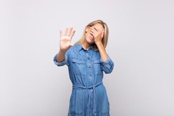  covering face with hand and putting other hand up front to stop camera, refusing photos or pictures