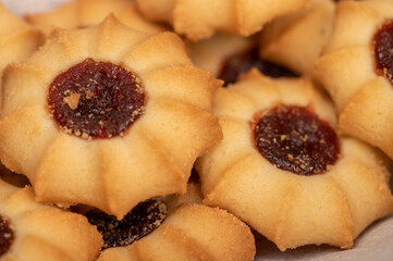Homemade pastry cookies with jam on a background of homespun fabric with a rough texture, close-up, selective focus.