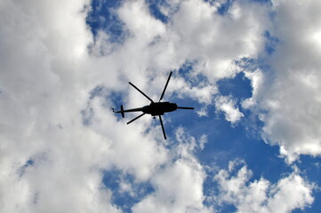 Fototapeta na wymiar Helicopter against blue sky with clouds