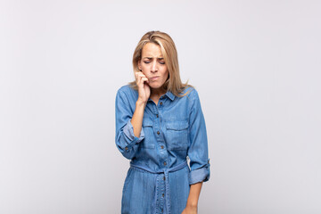  holding cheek and suffering painful toothache, feeling ill, miserable and unhappy, looking for a...
