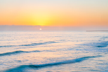 Obraz premium Sunset over ocean waves