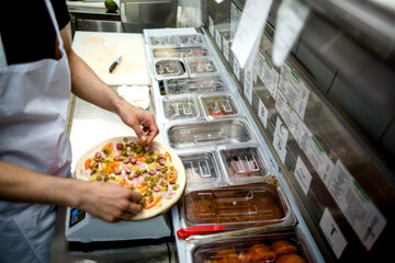 
the chef prepares pizza. weighs the ingredients