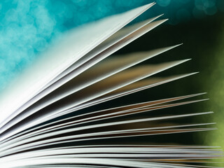 open book leaves, close-up, on a blue background with bokeh effect, fairy tale, copy space