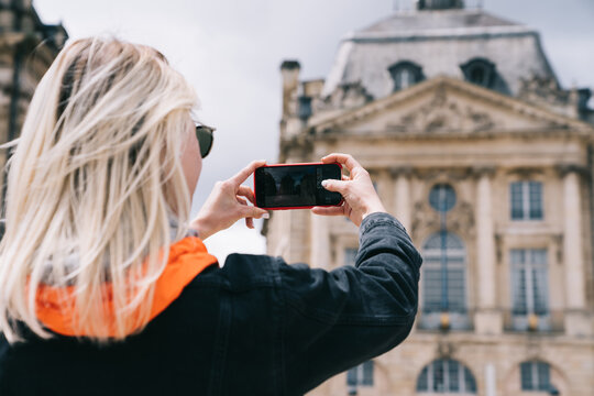 Female traveler taking picture of old building in France