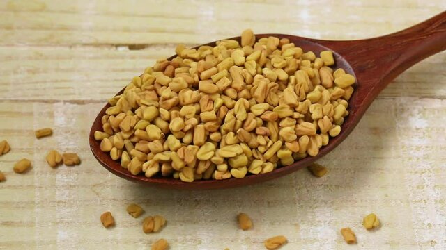 Spoon with fenugreek seeds close up