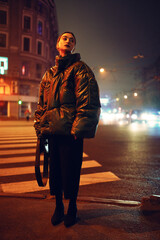 Woman on crosswalk in yellow light at night