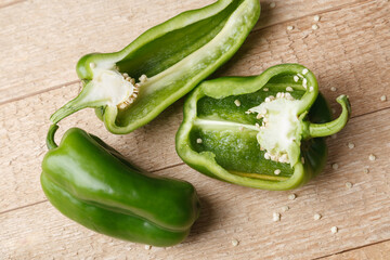 Group of half slisced green bell peppers on wooden rustick table. Top View