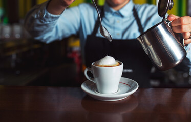 Female barmen make coffee with milk