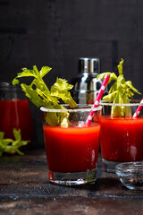 bloody mary alcoholic cocktail in glasses on dark background, vertical