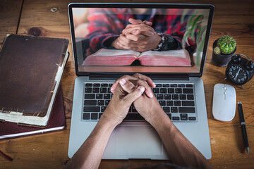 Hands praying on computer laptop, Online church for cell group, Home church during quarantine...