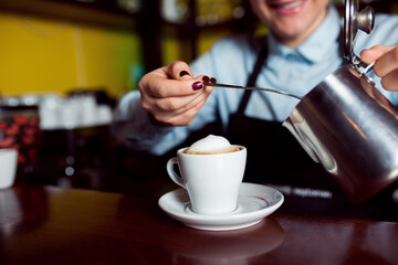 Female barmen make coffee with milk