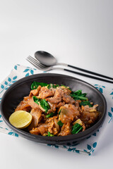 Soy sauce noodles with pork in a black plate