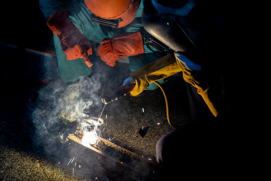Experienced workers in the factory welding steel with electric welding machine.