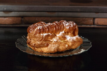 Eclair filled with pastry cream (custard) and topped with icing sugar