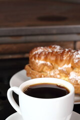 Coffee cup with espresso and eclair