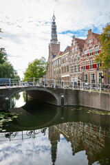 Obraz premium Traditional dutch canal houses and church tower in the old part of the city of Leiden, Holland