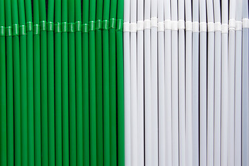 top view of white and green plastic drinking  straws in a row