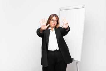  smiling and looking friendly, showing number nine or ninth with hand forward, counting down