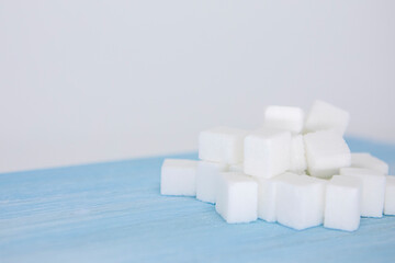 sugar cubes on white background and blue table
