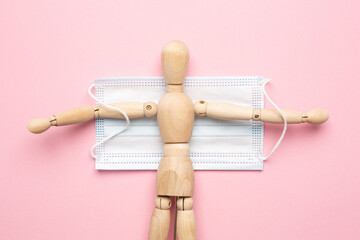 Wooden man with medical mask, second wave, protection from the covid virus