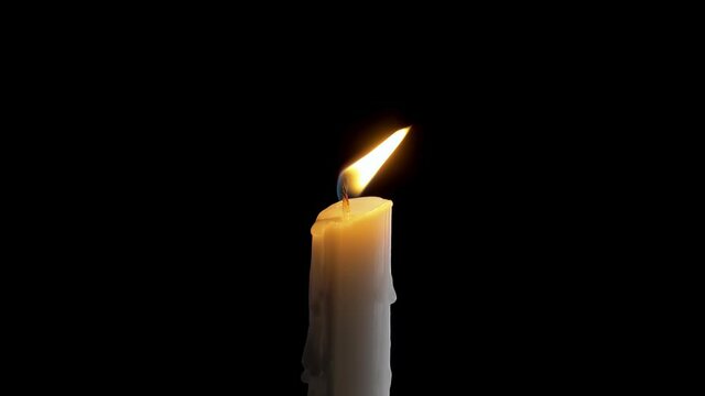 A single white candle burning.Isolated candle burning with dark background.White paraffin candle with yellow shades burns on a black background.Background or illustration of remembrance or celebration