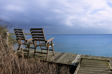 Calm down at the coast - empty chairs at the waterfront