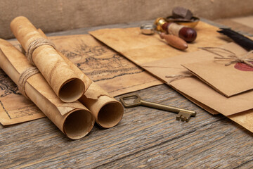 The surface of the old wooden table. On the table are old scrolls, an old map, an envelope with a seal, an iron key to the lock.