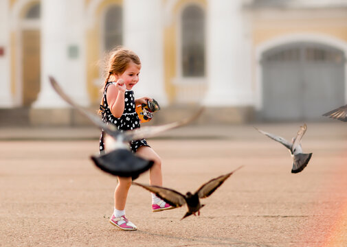 
Little Girl Chasing Pigeons