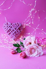 
Fresh roses on a pink background, hearts, illumination, concept of romantic congratulations on Valentine's Day, happy birthday cards, wedding invitation, interior decoration
