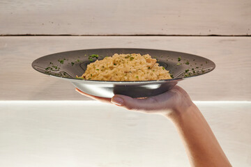 Waiter holding risotto in the restaurant