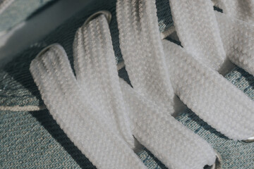 Blue sneakers with white laces on a light blue background. Trendy fashionable casual concept.