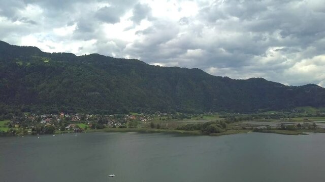 Aerial view on the upper ends of Ossiacher Lake in Carinthia, Austria with its moor and marshlands on a summer day with great cloudscape.