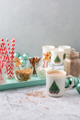 Hot Cocoa Bar with Christmas Cups and Decorations; Multiple Toppings Pictured; White and Gray Countertop
