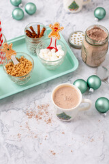 Hot Cocoa Bar with Christmas Cups and Decorations; Multiple Toppings Pictured; White and Gray Countertop