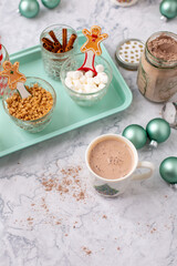 Hot Cocoa Bar with Christmas Cups and Decorations; Multiple Toppings Pictured; White and Gray Countertop