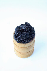 Blackberry in a wooden bowl on a white background - 381959711