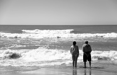 Fototapeta na wymiar couple looking at the sea on the beach