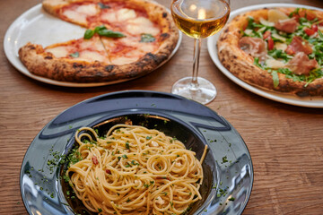 Spaghetti carbonara, pizza, glass of white wine