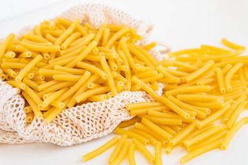 Raw dry uncooked Macaroni pasta spaghetti noodle on white bowl wooden background for basil tomato pesto sauce Homemade Italian food organic whole wheat vegan spaghetti for a healthy meal