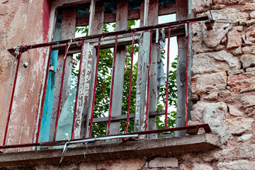 old window with broken glass and red window railing