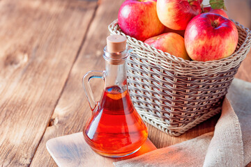 Processing of an agricultural crop of red and green apples. Home canning, healthy diet vegetarian food. Apple cider vinegar, juice, cider in a glass jar next to ripe fruit