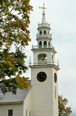Classic white steeple with weathervane and clock. Built in 1775, this building served as the original Meeting House for the town of Jaffrey, New Hampshire.