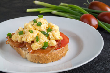 scrambled eggs with tomatoes on a white plate.