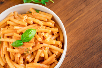 Healthy organic Italian macaroni homemade fresh pasta spaghetti noodles cook with basil tomato garlic pepper sauce with vegan vegetarian recipe in white bowl on wooden vintage table