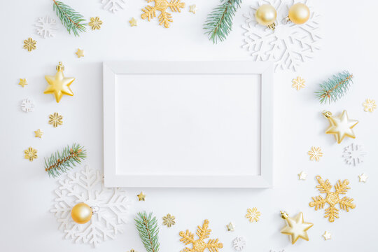 Mockup white frame with fir branches, christmas baubles decoration and snowflakes on a white background